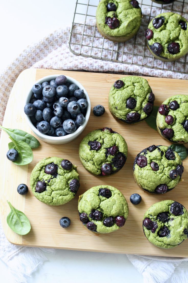 blueberries and spinach muffins on a cutting board with text overlay that reads spinach blender muffins with blueberries simple & gluten free