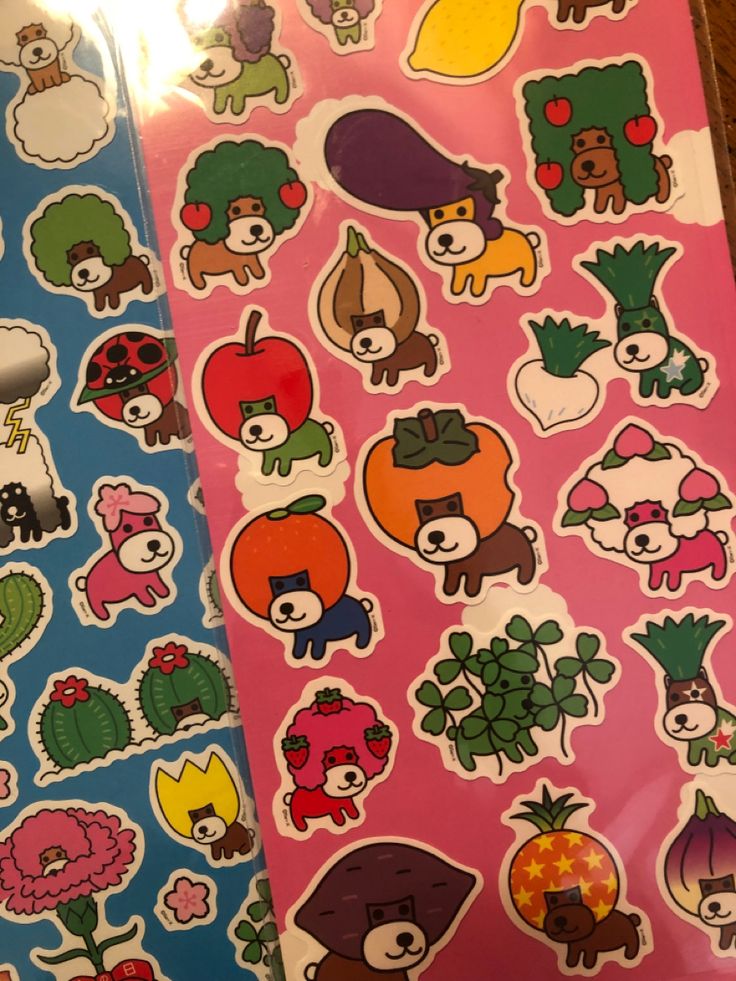 two sheets of stickers with animals and plants on them, one in pink the other in blue