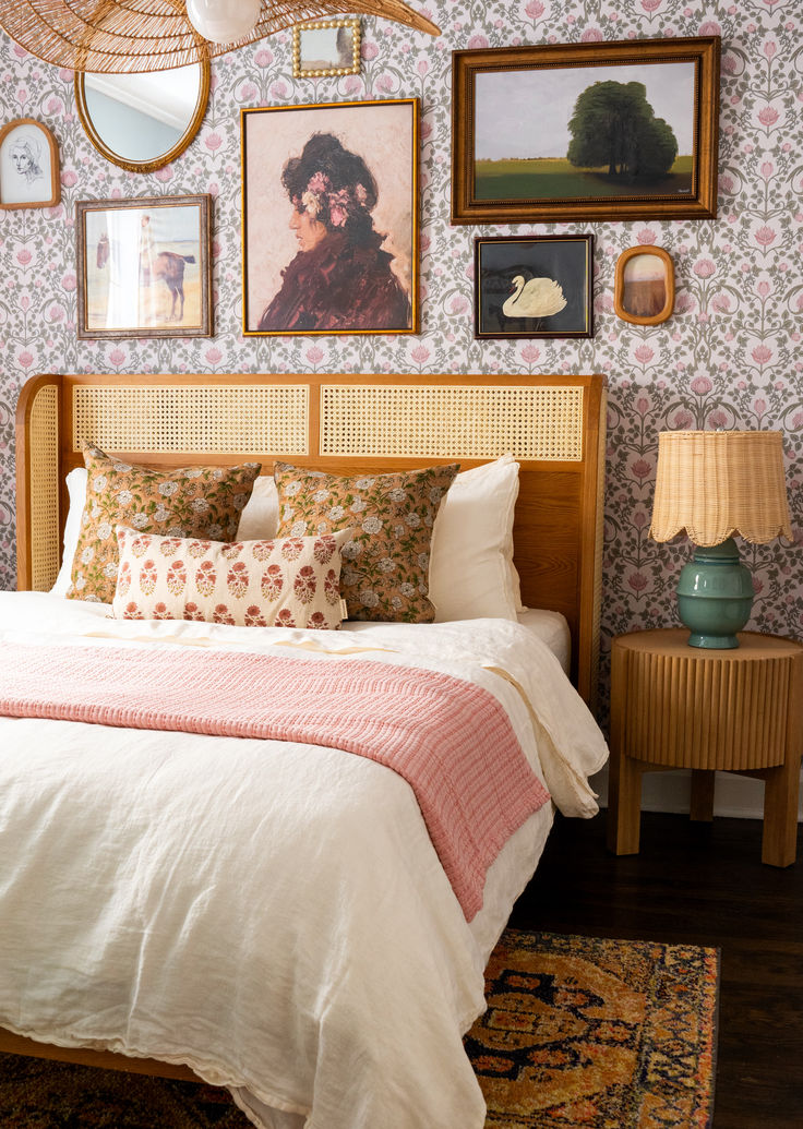 a bed sitting in a bedroom next to a wall with pictures hanging on the walls