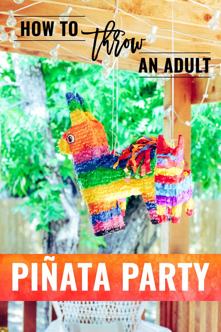 a colorful pinata horse hanging from a wooden porch over a white wicker table