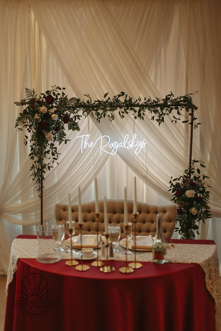 the table is set up with candles, flowers and greenery for an elegant wedding reception