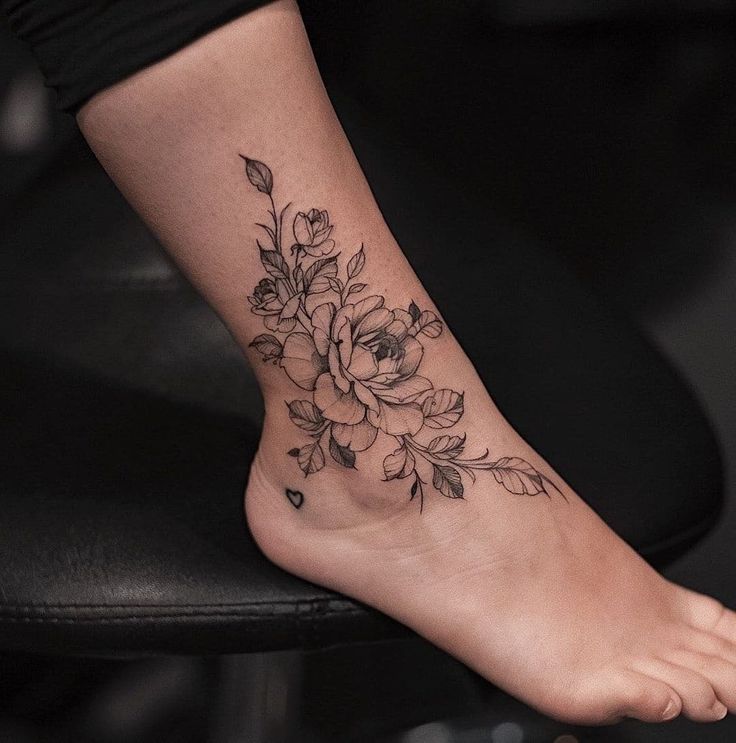 a woman's foot with a flower tattoo on it