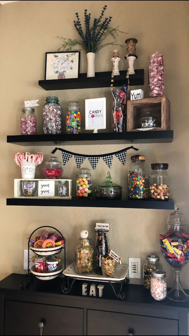 two shelves with candy and candies on top of them in front of a wall