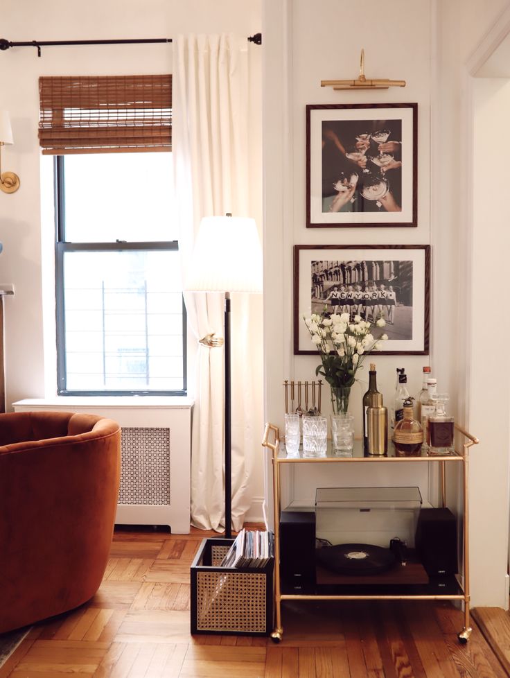 a living room filled with furniture and pictures on the wall next to a window,