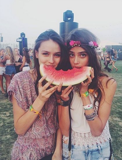 two girls eating watermelon at an outdoor festival