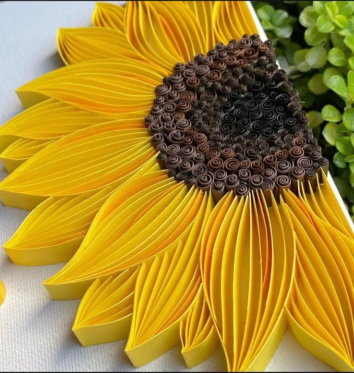 a sunflower made out of paper sitting on top of a table