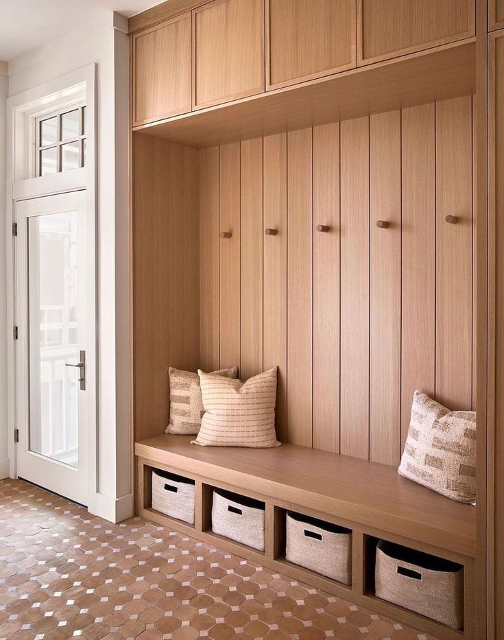 a wooden bench sitting in the middle of a room next to a white door and window