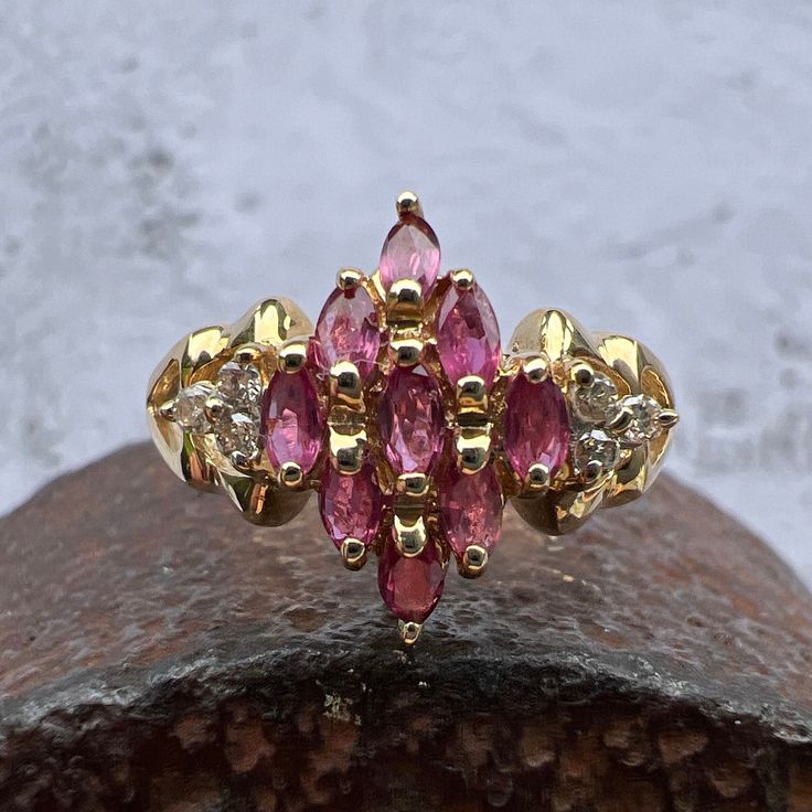 Gorgeous Rubies accented by Diamonds set in a Lovely 14k Yellow Gold Cluster Ring. US Size 7 3/4 Rubies approximately 1.1 ctw Diamonds 0.08 ctw, approximately  Diamond Grade: J / I Widest Point measures approximately 13.6 mm. Back of the shank tapers down to 2.1 mm, approximately. Nicely weighted at 3.6 grams, approximately. Stamped 14K Ruby is the birthstone for July. Diamond is the birthstone for April. Diamond Cluster Ruby Ring With Diamond Accents, Marquise Cut Multi-stone Yellow Gold Diamond Ring, Marquise Cut Multi-stone Diamond Ring For Anniversary, Cubic Zirconia Marquise-cut Multi-stone Diamond Ring, Marquise Cut Multi-stone Cubic Zirconia Diamond Ring, Multi-stone Cubic Zirconia Marquise Cut Ring, Classic Diamond Ring With Multi-stone Marquise Cut, Classic Multi-stone Marquise Cut Diamond Ring, Classic Marquise Cut Multi-stone Diamond Ring