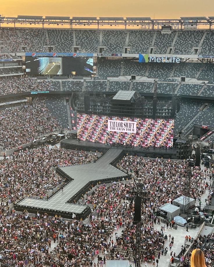 a large crowd at a concert in an arena with the stage set up for a concert