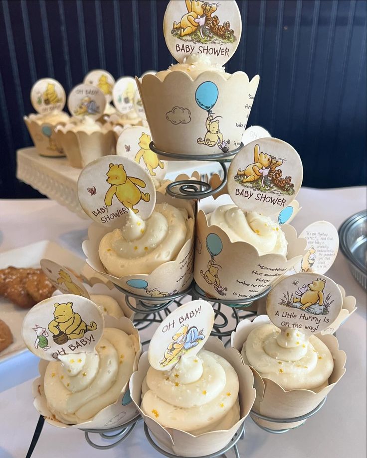 cupcakes with winnie the pooh frosting are arranged on a cake stand