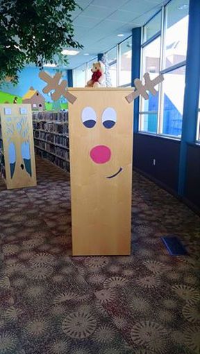 a cardboard box with reindeer faces on it in the middle of a library area,