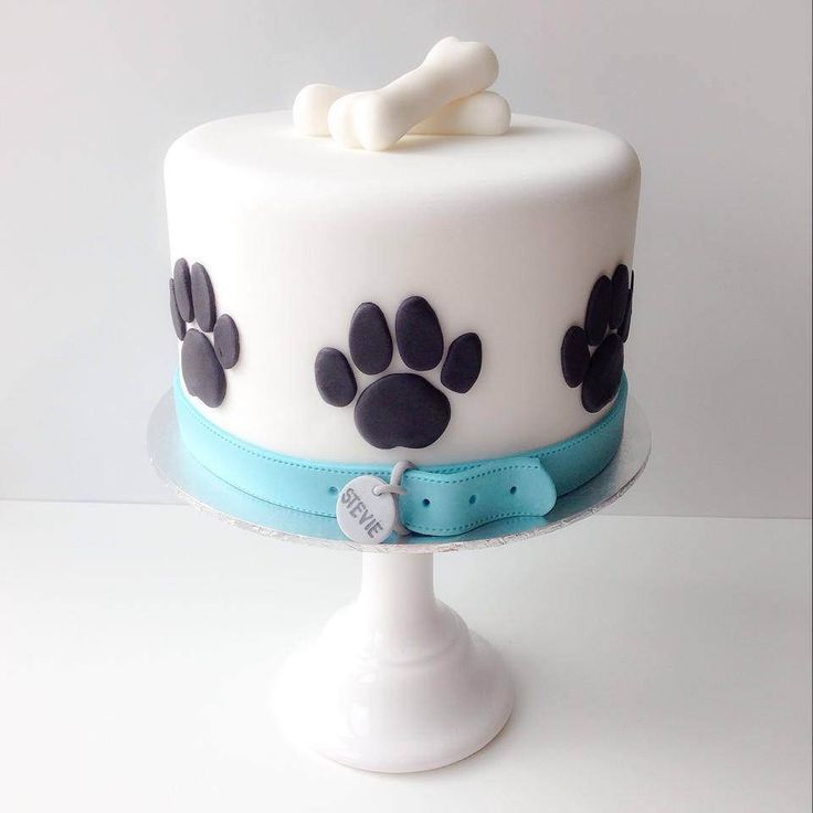 a white cake with black and blue paw prints on it