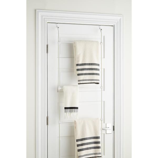 two towels are hanging on the wall in front of a white door with black and white stripes