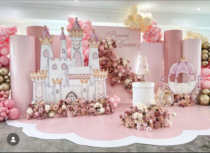 a pink and gold princess themed birthday party with balloons, flowers, and castle decorations