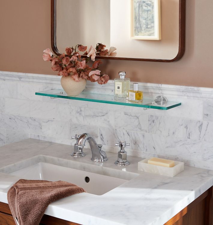 a bathroom sink with a mirror above it and a towel on the counter next to it