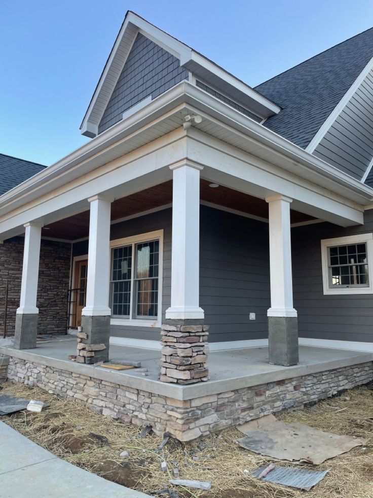 a house with gray siding and white pillars