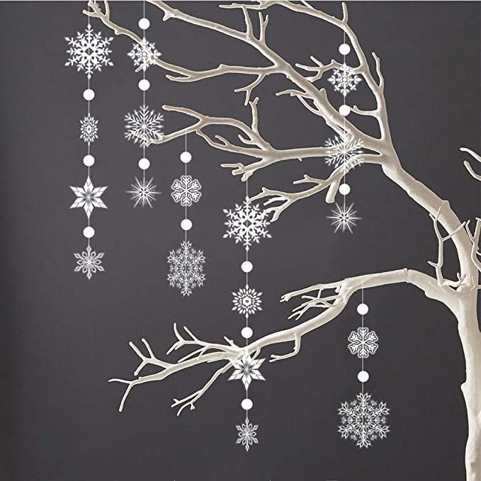 a tree with snowflakes hanging from it's branches in front of a dark background