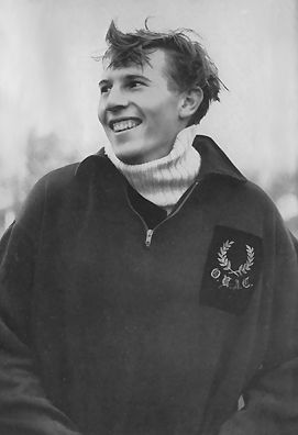 an old black and white photo of a young man with his hands in his pockets