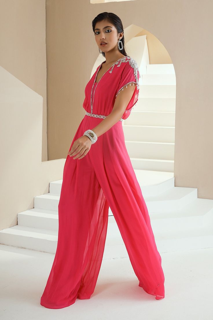 Hot pink draped jumpsuit with embroidered in pearls, glass beads and white beads.
Components:1
Pattern:Embroidered
Type of Work:Floral Motifs
Neckline:V-Neck
Sleeve Type:Cap
Fabric:Georgette, Lining: Satin
Color:Pink
Other Details:
Tassel hem sleeves
Pleated details
Occasion:Sangeet - Aza Fashions Pink Sequined Jumpsuits And Rompers For Summer, Elegant Pink Beach Jumpsuits And Rompers, Elegant Pink Jumpsuits And Rompers For Beach, Elegant Pink Jumpsuit For The Beach, Embellished Evening Jumpsuits And Rompers For Summer, Embellished Jumpsuits And Rompers For Evening In Summer, Embellished Evening Jumpsuits For Summer, Embellished Jumpsuits And Rompers For Summer Evenings, Festive Floor-length Jumpsuits And Rompers For Summer