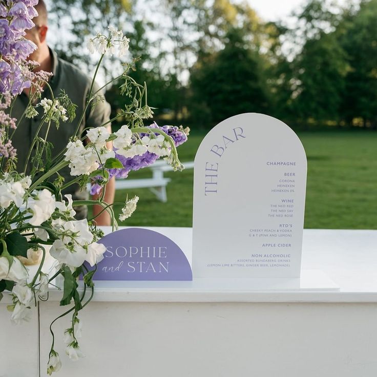 a table with flowers on it and a sign for the name of the place card