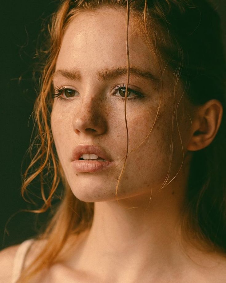 a woman with freckled hair is looking at the camera