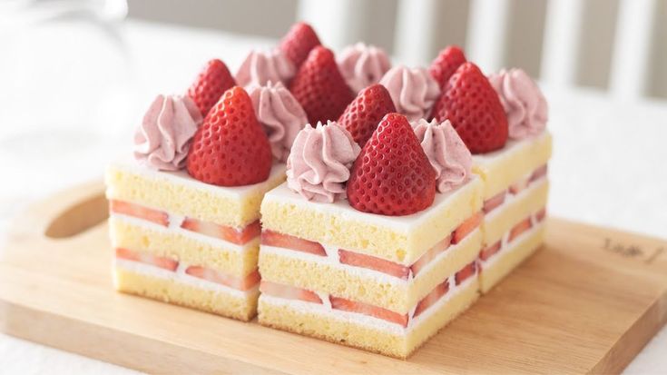 there is a piece of cake that has strawberries on it and frosted with pink icing