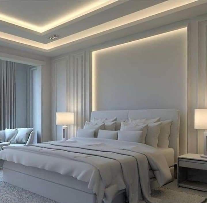 a large white bed sitting in a bedroom next to two lamps on either side of the bed