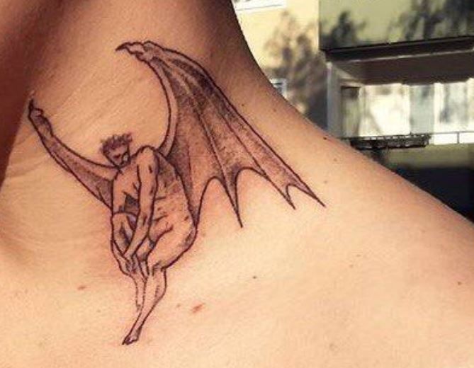 a tattoo on the back of a woman's neck with a drawing of a demon