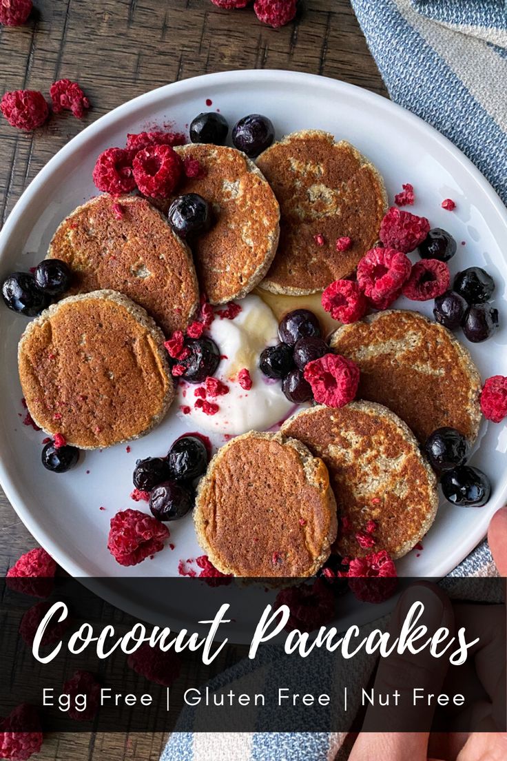 coconut flour pancakes with blueberries and raspberries on a white plate