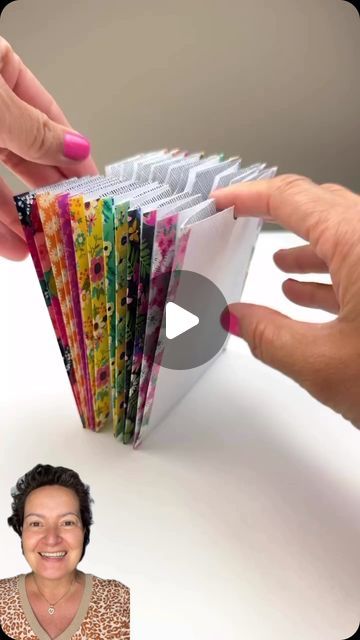 a woman is holding up some colorful papers