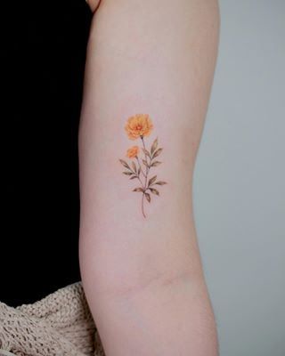 a woman's arm with a flower tattoo on the left side of her arm