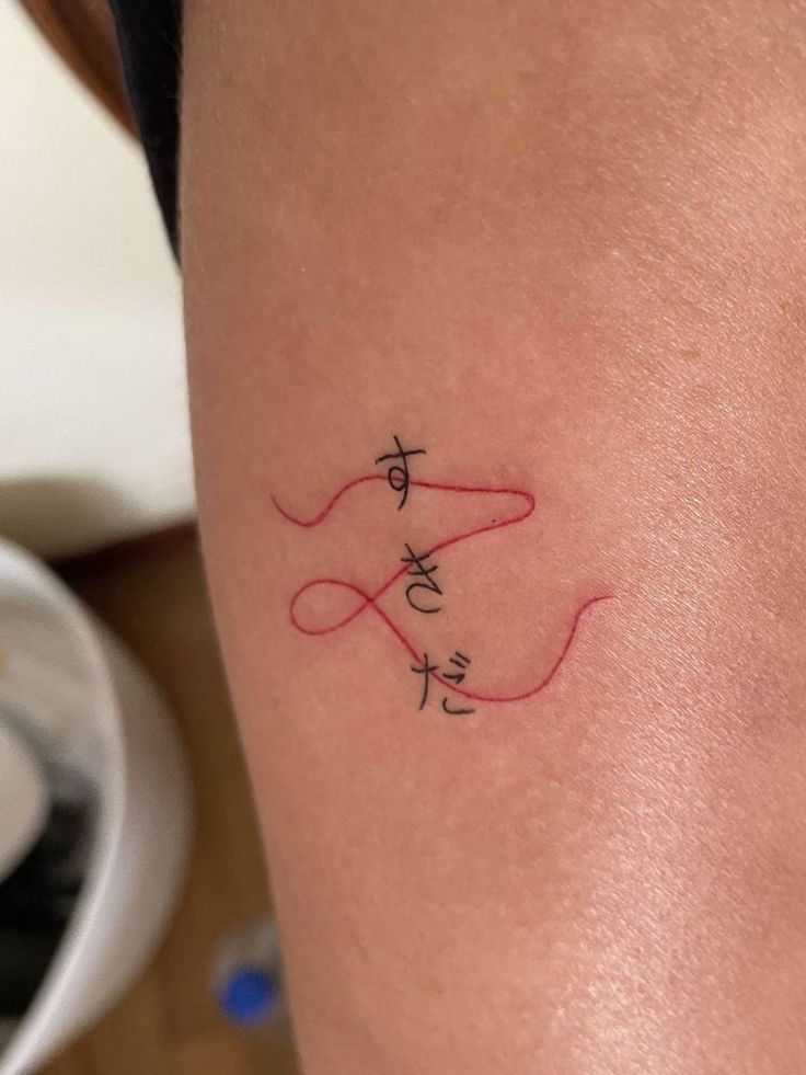 a woman with a tattoo on her leg that says love and is holding a string