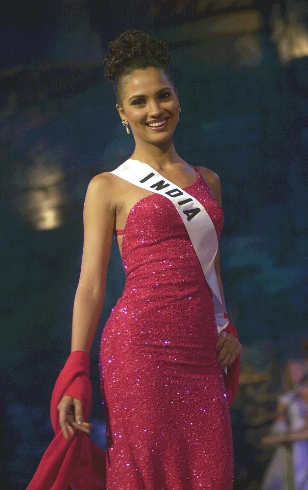 a woman in a pink dress is smiling at the camera while wearing a tiara