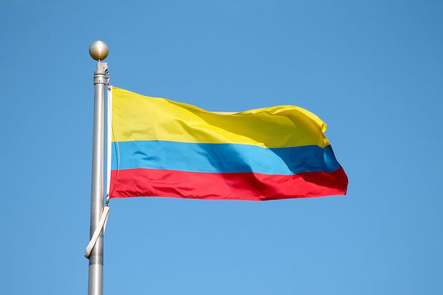 a flag flying in the wind on a clear day with a blue sky behind it