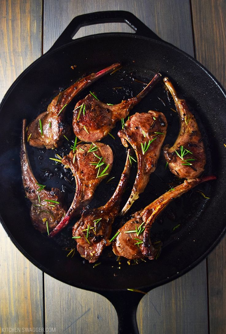 steaks are cooking in a skillet on the table