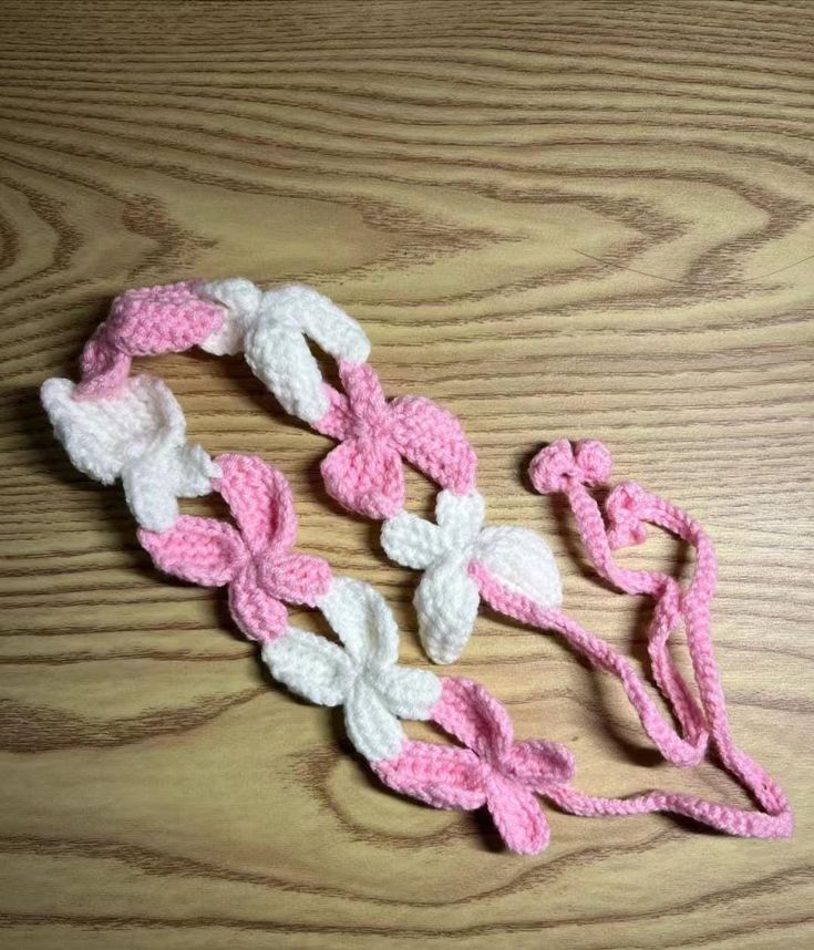 crocheted pink and white ribbon on wooden table