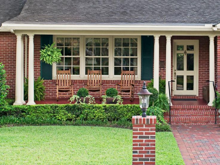 a red brick house with white trim and green shutters on the front door is shown