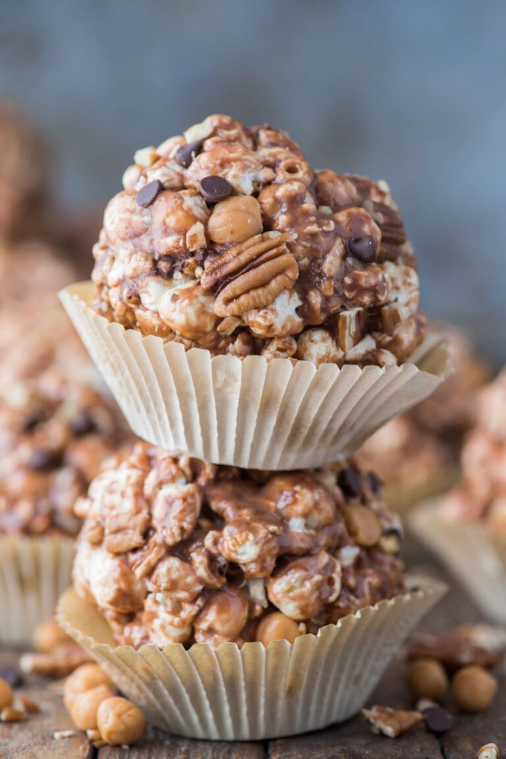 three cupcakes stacked on top of each other with nuts and chocolate chips around them