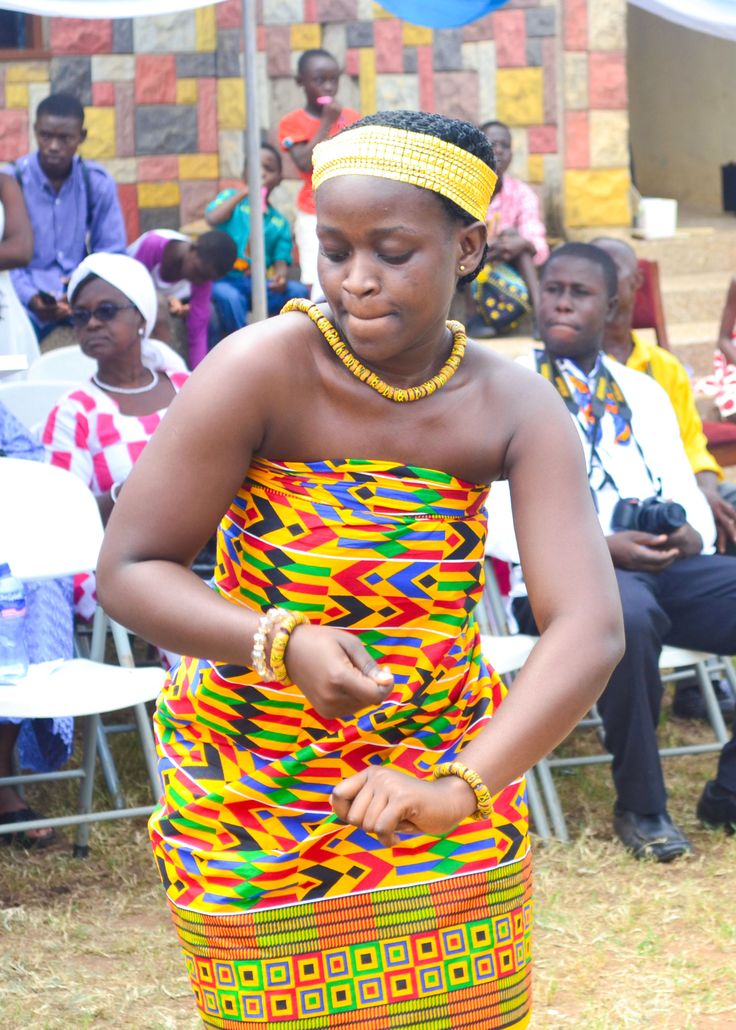 a woman in a colorful dress is looking at her cell phone while people watch from the sidelines