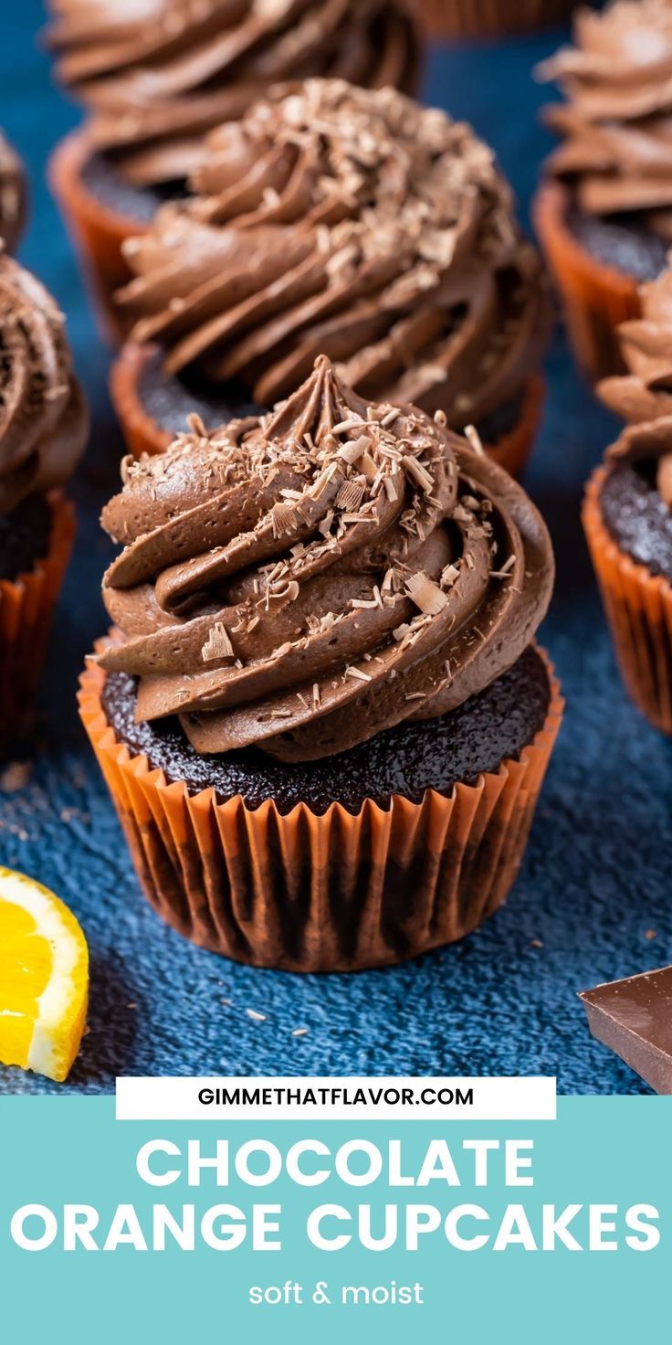 chocolate orange cupcakes with frosting on top and an orange slice next to them