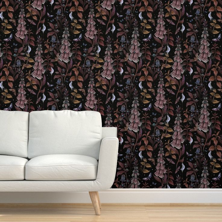 a white couch sitting in front of a wall with a pattern on it's side