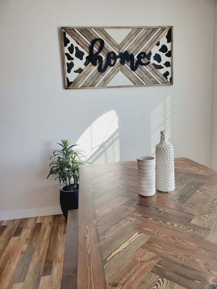 a wooden table with two vases on it and a sign above the table that says bone