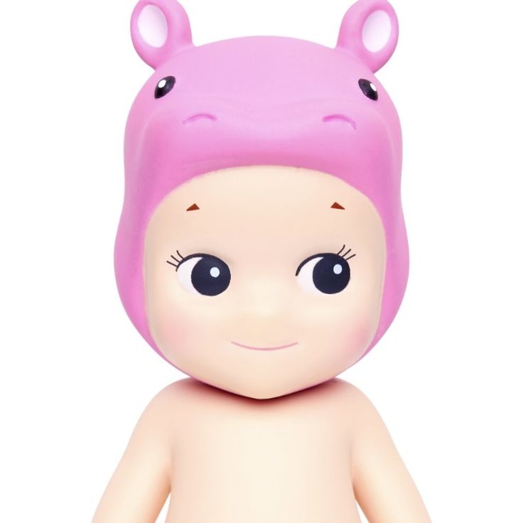 a small toy doll with big eyes and a pink hat on it's head