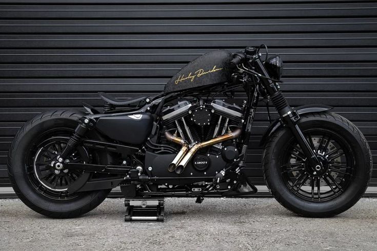 a black motorcycle parked in front of a garage door