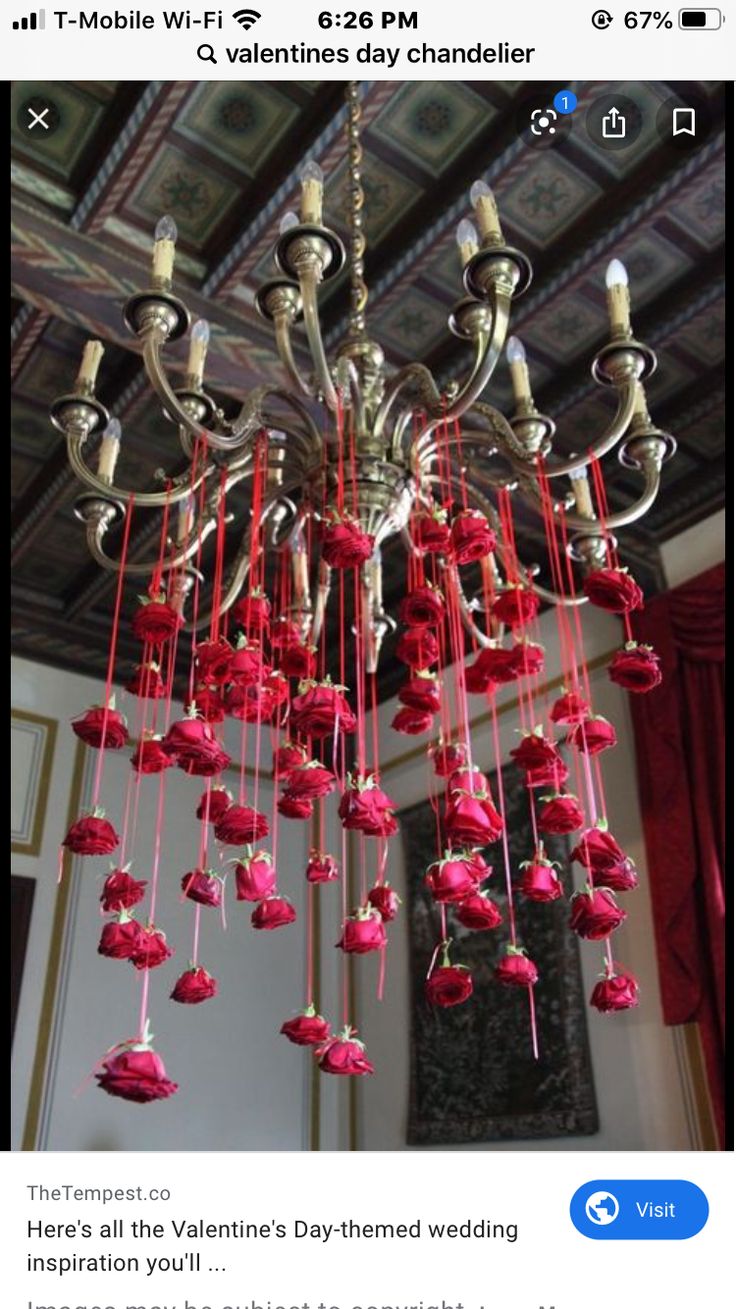 a chandelier with red flowers hanging from it's sides and the words valentine's day written on it