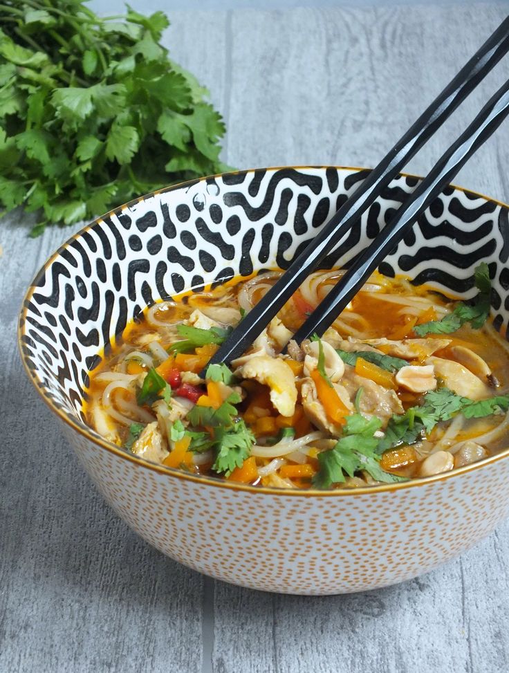 two chopsticks sticking out of a bowl of soup