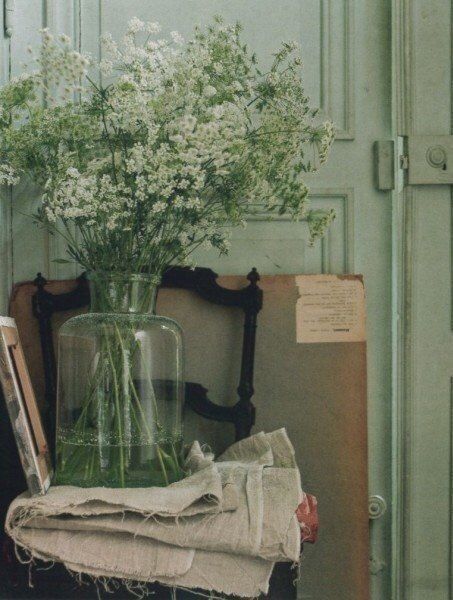 a vase filled with white flowers sitting on top of a table next to a box