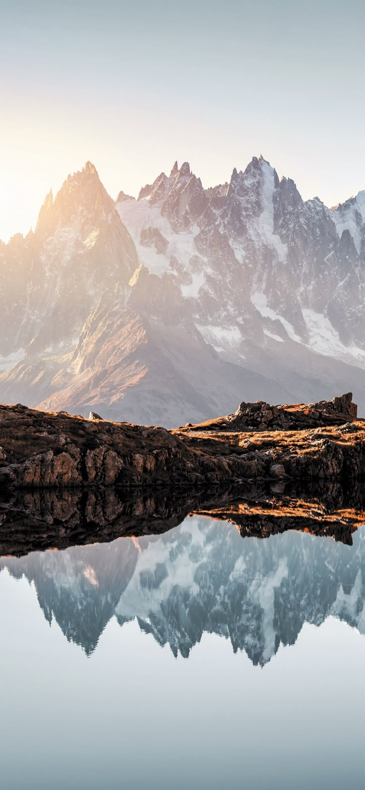 the mountains are reflected in the still water