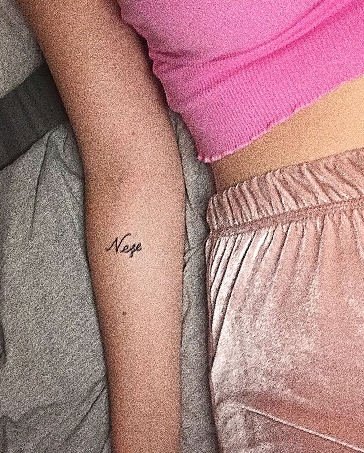 a woman's arm with a small tattoo on the left side of her right arm