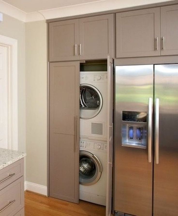 a stainless steel refrigerator freezer next to a washer and dryer in a kitchen